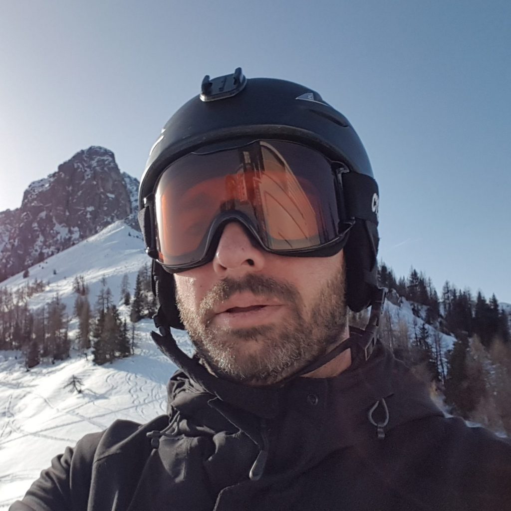 Klaus with helmet and ski goggles in front of a mountain in winter skiing